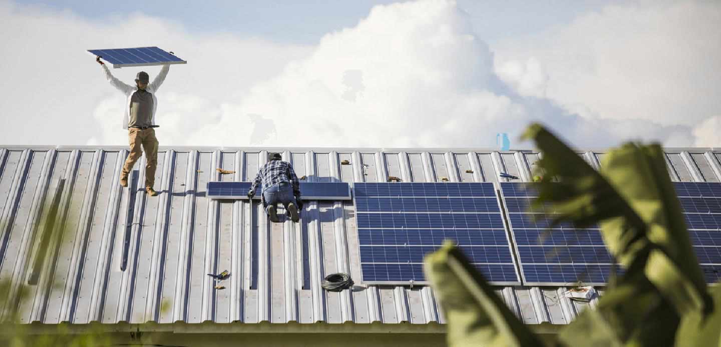People installing solar panels on a roof top