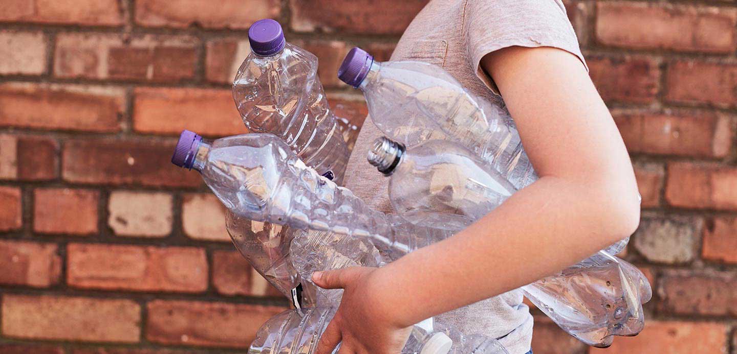 A person carrying plastic bottles for reycling